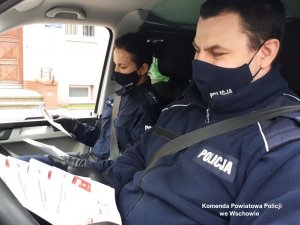 policjanci z ulotkami informacyjnymi &quot;Kwarantanna domowa&quot;