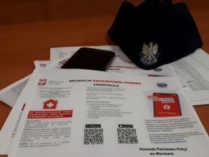 policjanci z ulotkami informacyjnymi &quot;Kwarantanna domowa&quot;