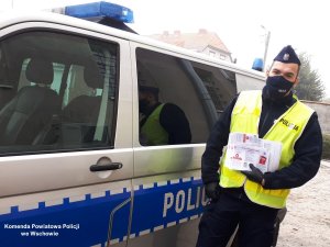 policjanci z ulotkami informacyjnymi &quot;Kwarantanna domowa&quot;