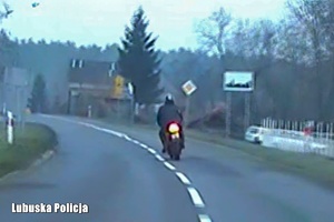 Motocyklista jadący po jezdni.